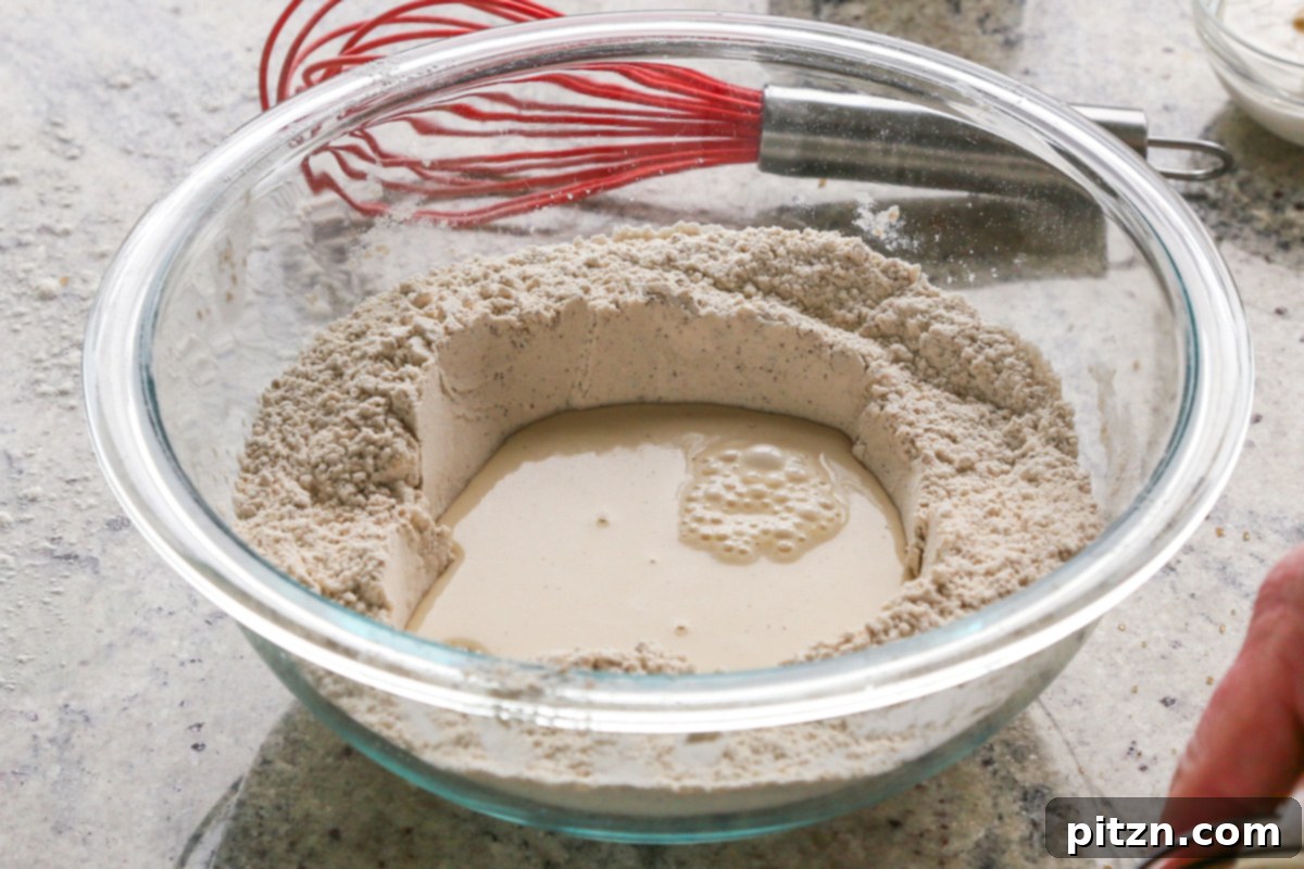 Luscious Triple Ginger Vegan Gingerbread Cake 11 A well created in the dry ingredients of the gingerbread cake batter, with non-dairy milk being poured into its center.