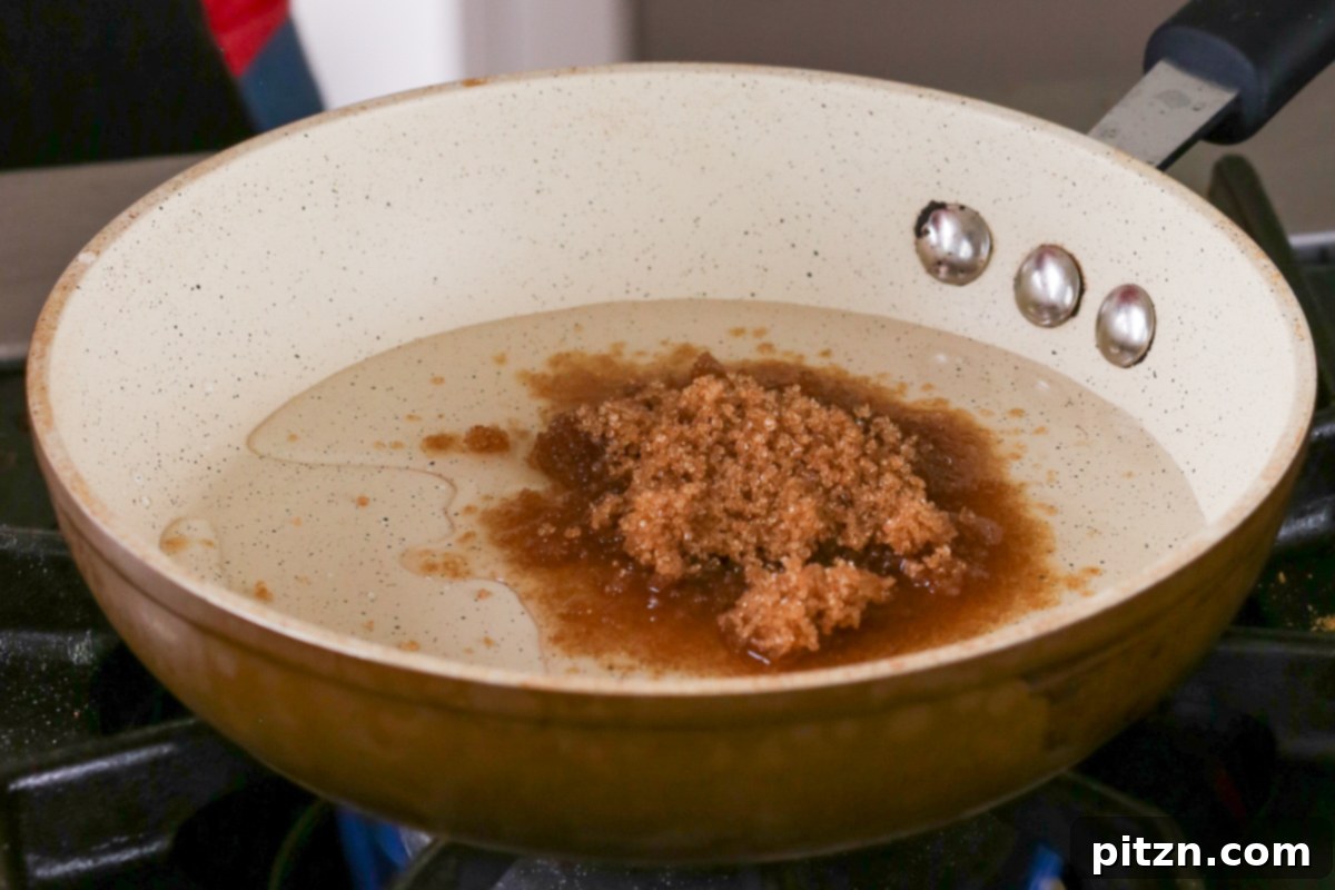 Luscious Triple Ginger Vegan Gingerbread Cake 18 Brown sugar being dissolved in water in a small saucepan over medium heat, forming the base for the sweet ginger glaze.