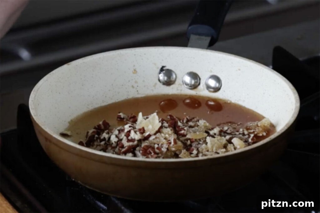 Luscious Triple Ginger Vegan Gingerbread Cake 20 Chopped pecans and candied ginger being stirred into the warm, thickened ginger syrup in a saucepan, creating the final glaze topping.