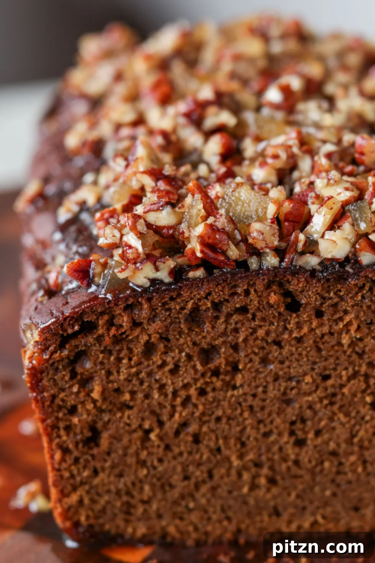 Luscious Triple Ginger Vegan Gingerbread Cake 4 A detailed close-up of a slice of vegan gingerbread cake, showcasing its light, fluffy internal structure, rich color, and the glistening texture of the sweet-and-spicy ginger glaze on top.