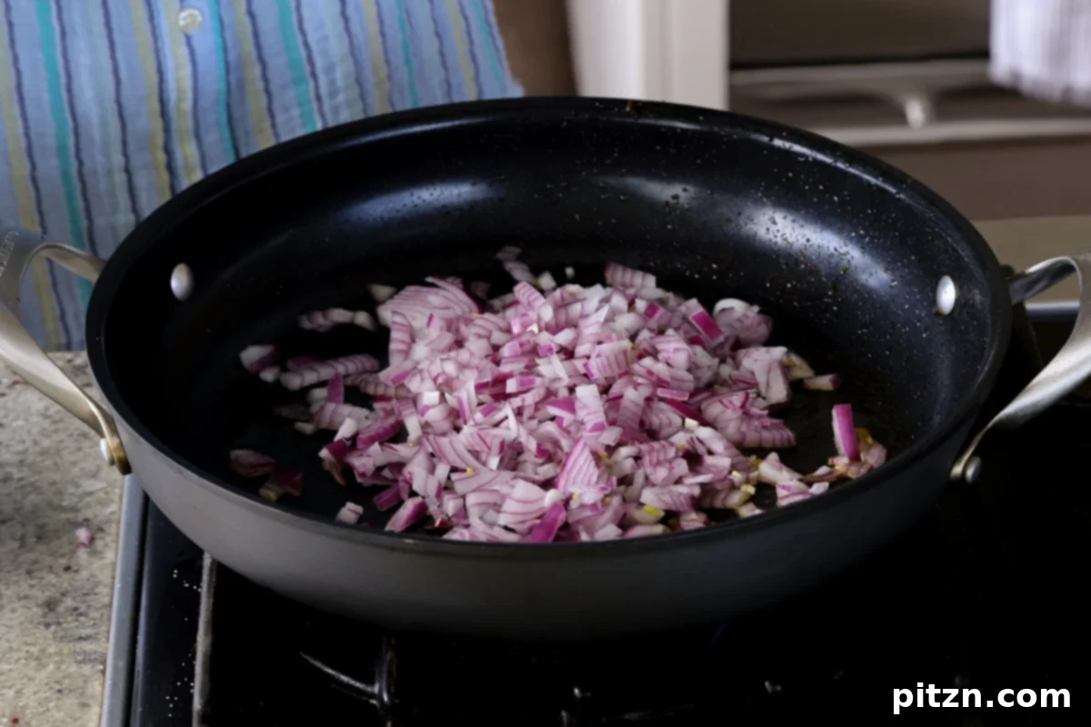 Robust Vindaloo Potato and Lentil Curry 12 onions in the pan before cooking