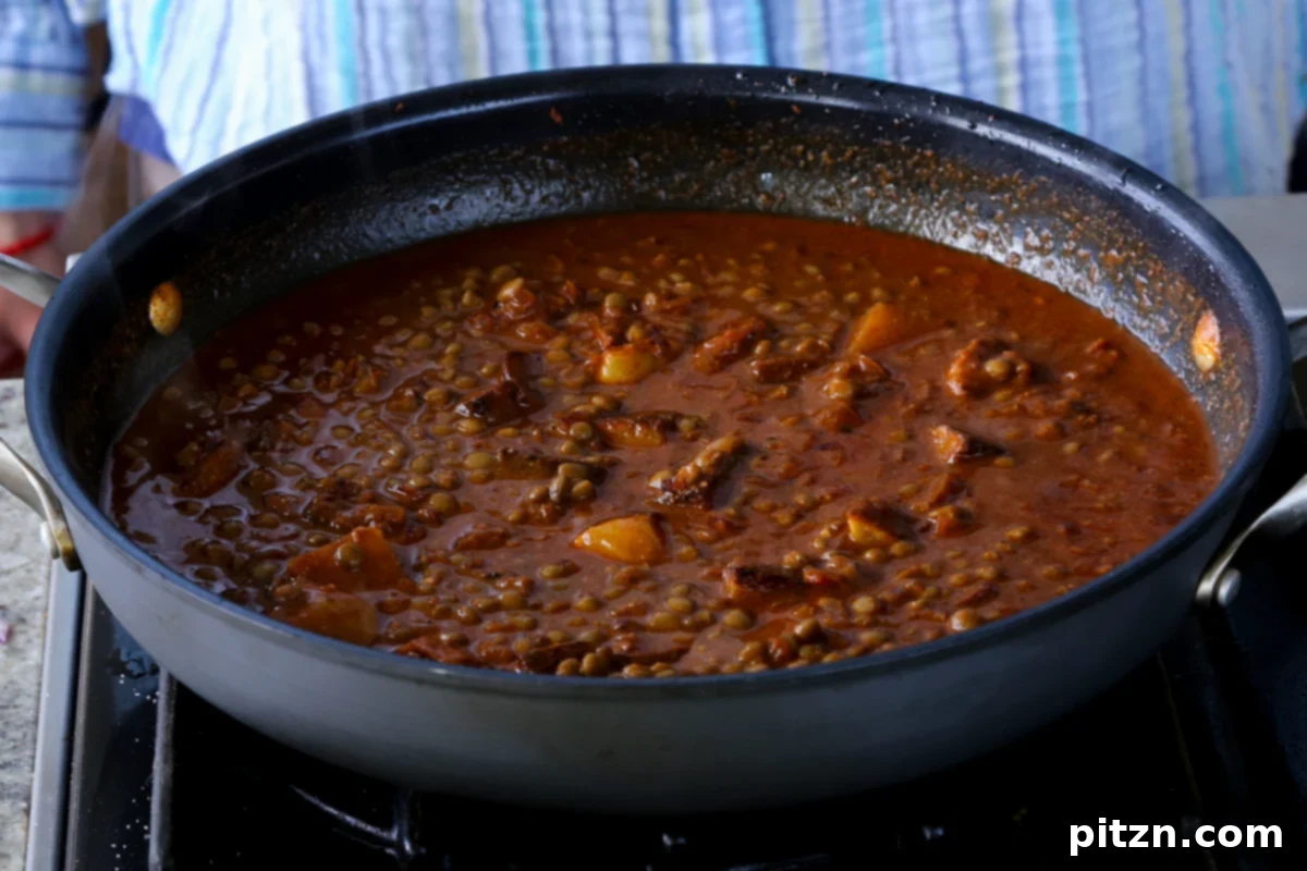 Robust Vindaloo Potato and Lentil Curry 19 adding potatoes to the vindaloo sauce
