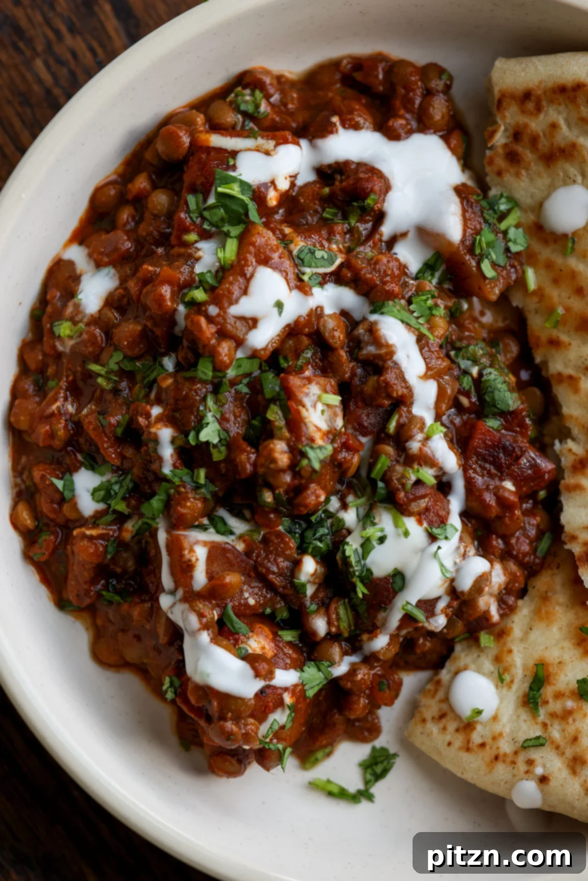 Robust Vindaloo Potato and Lentil Curry 3 lentils vindaloo on a plate with toppings and naan