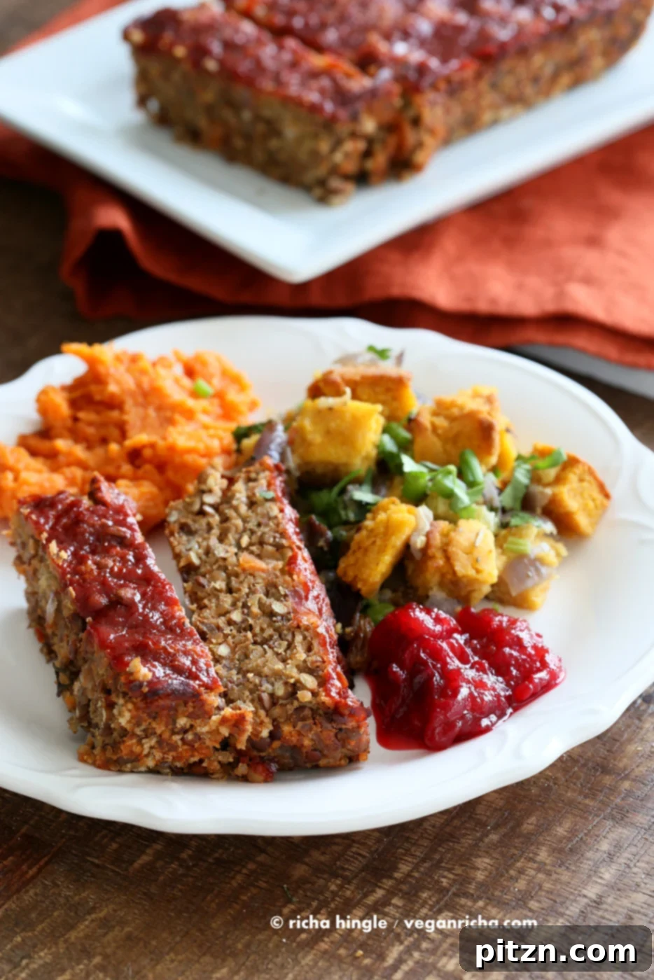 Plant Powered Lentil Quinoa Loaf 4 A festive holiday plate featuring the Vegan Lentil Quinoa Loaf served with pumpkin cornbread stuffing, spicy cranberry sauce, and mashed sweet potatoes.