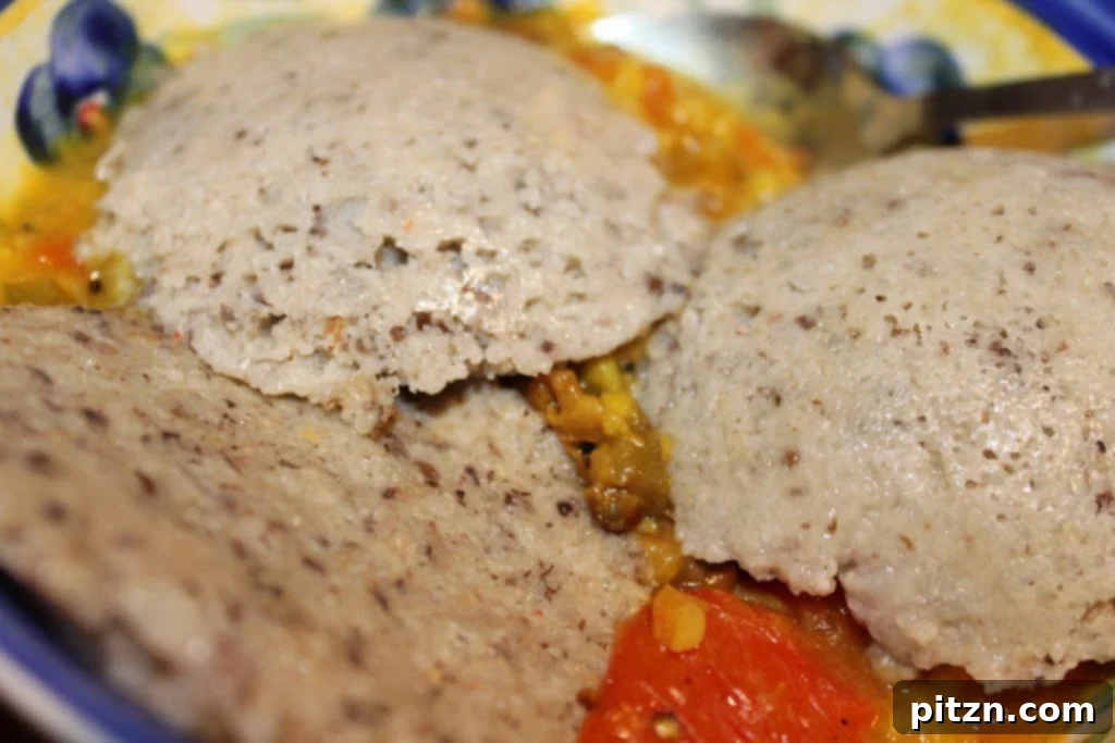 A close-up view of freshly steamed Multi-Lentil Idli, showcasing their soft, round, and fluffy texture on a plate.