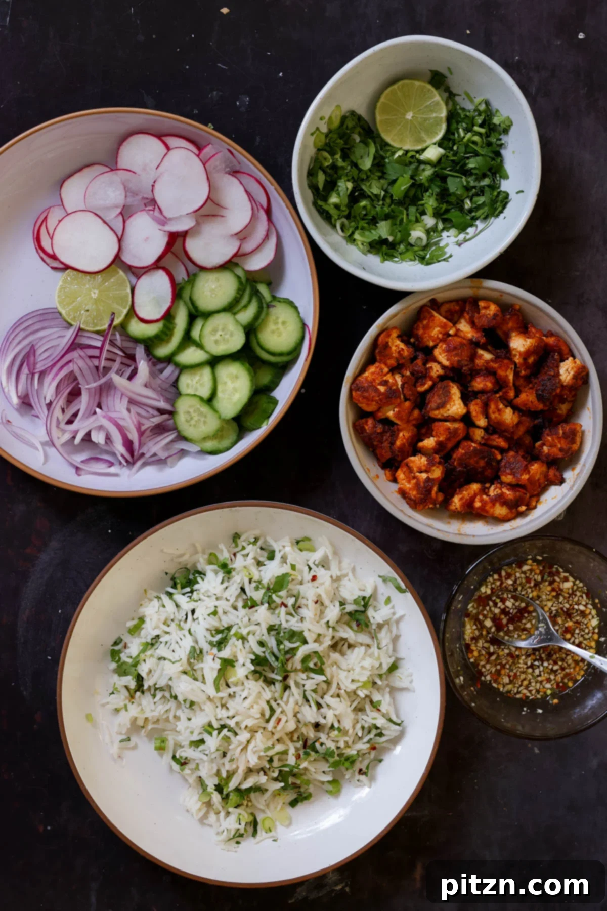 30-Minute Harissa Tofu Bowls for All Diets 3 harissa tofu, herbed rice, fresh veggies, herbs, and dressing in bowls on a dark table