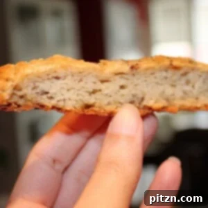 Aromatic Fennel Nigella Flatbread 4 A slice of fennel and nigella seeds savory flat bread being held towards the camera, showcasing its soft interior
