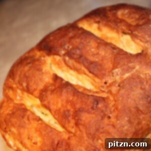 A loaf of mango cardamom raisin multigrain bread on a wooden work surface