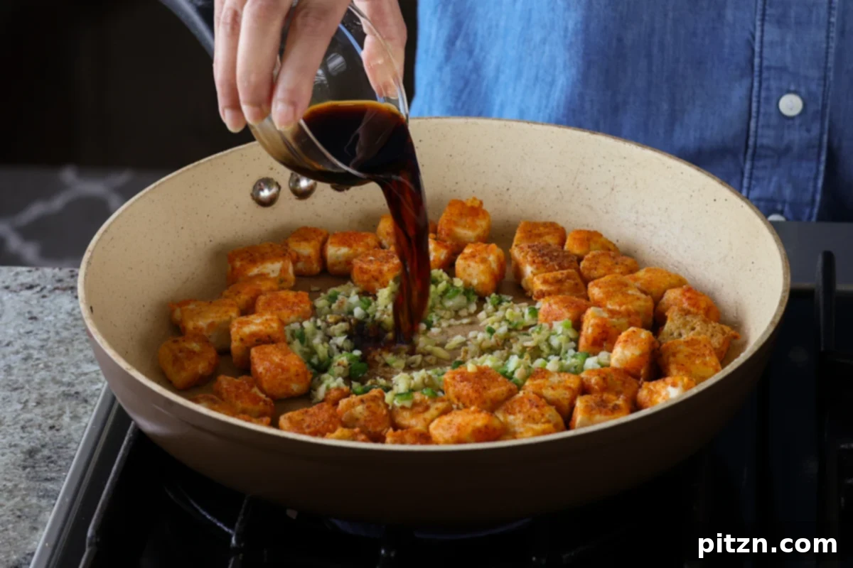 Flaky Indo Chinese Chilli Garlic Tofu Parcels 15 Pouring soy sauce and white vinegar into the pan with aromatics, forming the base of the Indo-Chinese sauce.