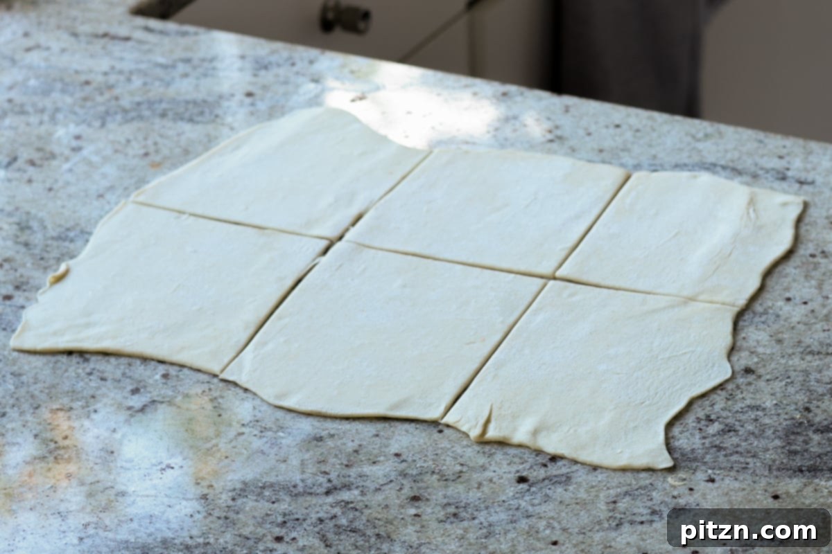 Flaky Indo Chinese Chilli Garlic Tofu Parcels 21 Puff pastry sheet precisely sliced into six equal squares, ready for filling.
