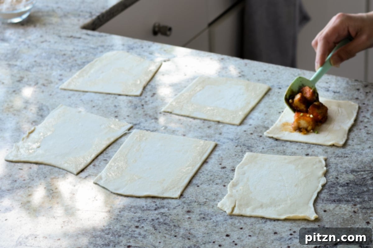 Flaky Indo Chinese Chilli Garlic Tofu Parcels 23 Spoonfuls of chilli garlic tofu filling placed onto the center of a puff pastry square, ready for folding.