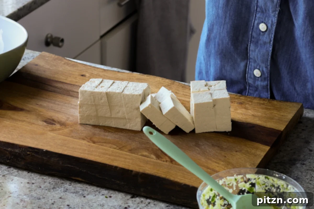 Flaky Indo Chinese Chilli Garlic Tofu Parcels 8 Dicing firm tofu into even cubes on a cutting board, a crucial step for crispy tofu.