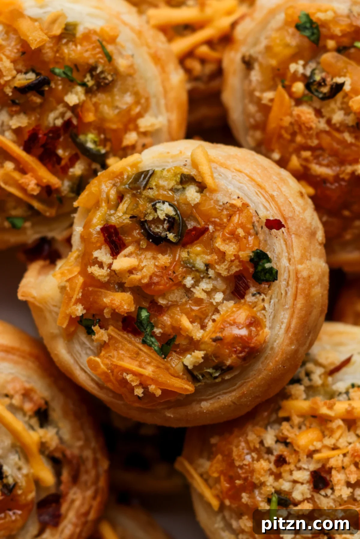 Vegan Jalapeño Popper Pinwheels 2 Close-up of golden-brown vegan jalapeño popper pinwheels arranged on a sophisticated serving platter, ready to be enjoyed.