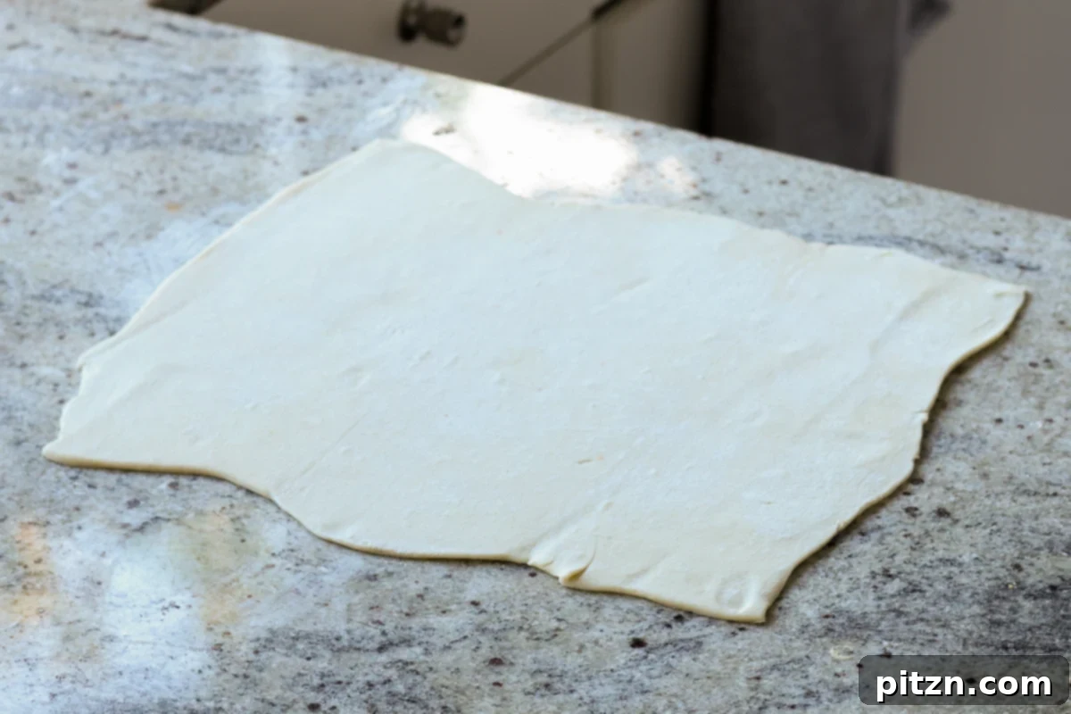 Vegan Jalapeño Popper Pinwheels 14 A rectangular puff pastry sheet, expertly rolled out and flattened on a floured surface, ready for filling.