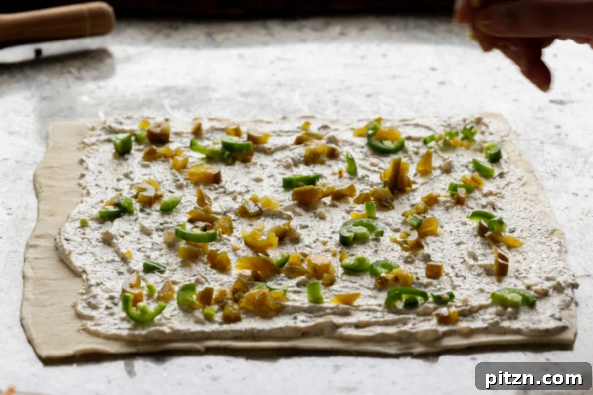 Vegan Jalapeño Popper Pinwheels 17 A hand sprinkling finely chopped fresh and pickled jalapeños generously over the creamy puff pastry filling.