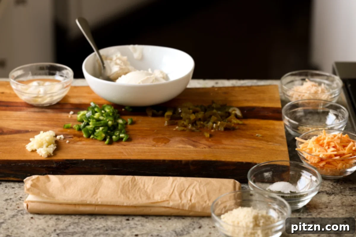 Vegan Jalapeño Popper Pinwheels 8 Prepped ingredients for jalapeño popper pinwheels, including finely chopped jalapeños, vegan cheeses, and mixed cream cheese filling, on a cutting board.