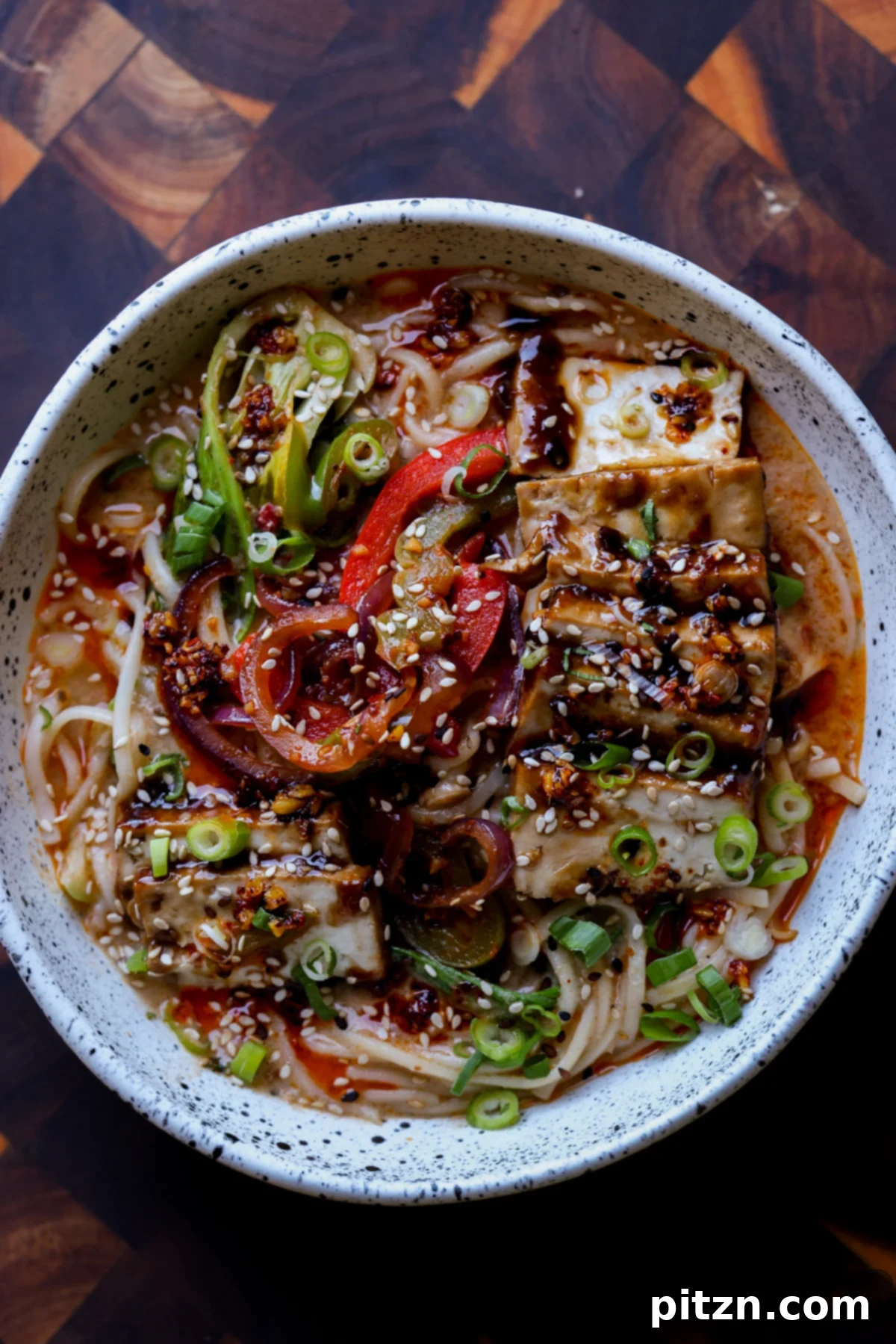 bowl of creamy tahini ramen with glistening teriyaki tofu on top, ready to be enjoyed