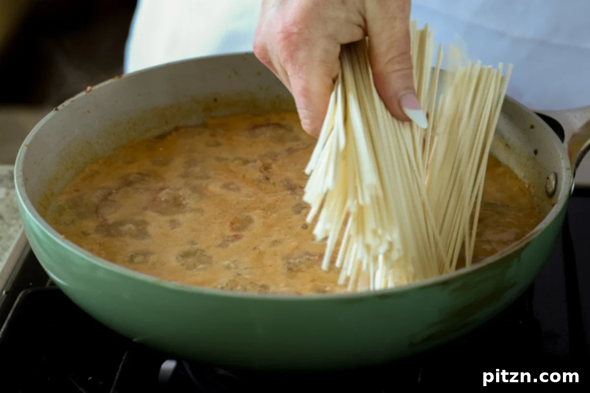 dried ramen noodles carefully added to the simmering tahini broth in the pan, ready to cook