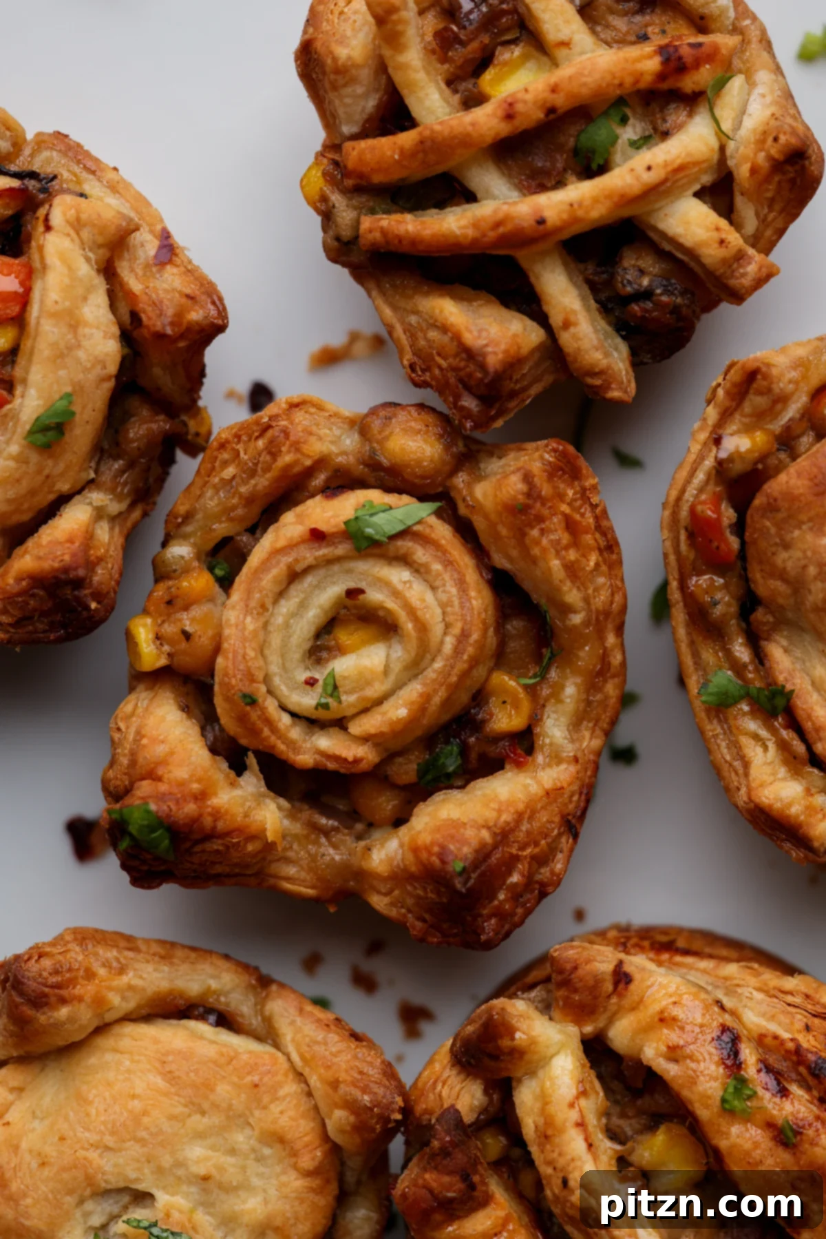 Golden-brown mini pot pies cooling on a wire rack, showcasing their flaky crust