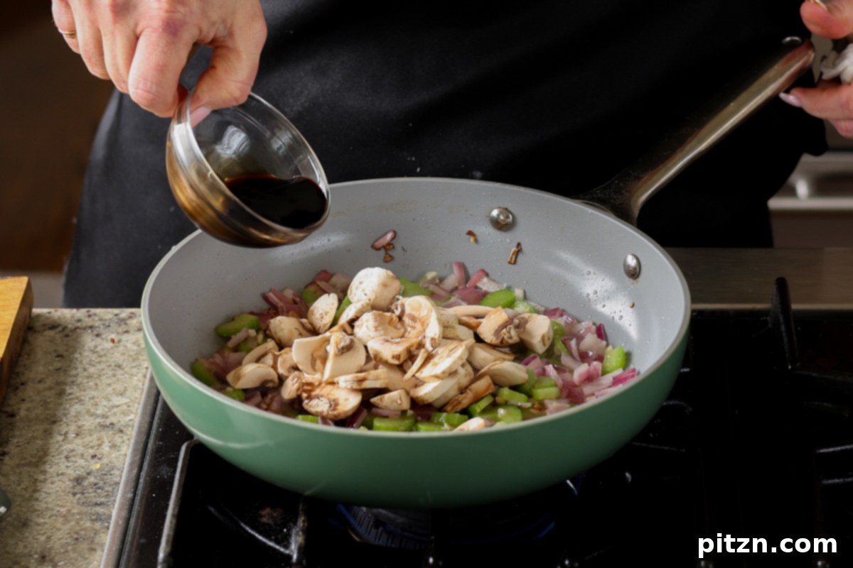Adding mushrooms and balsamic vinegar to the skillet.