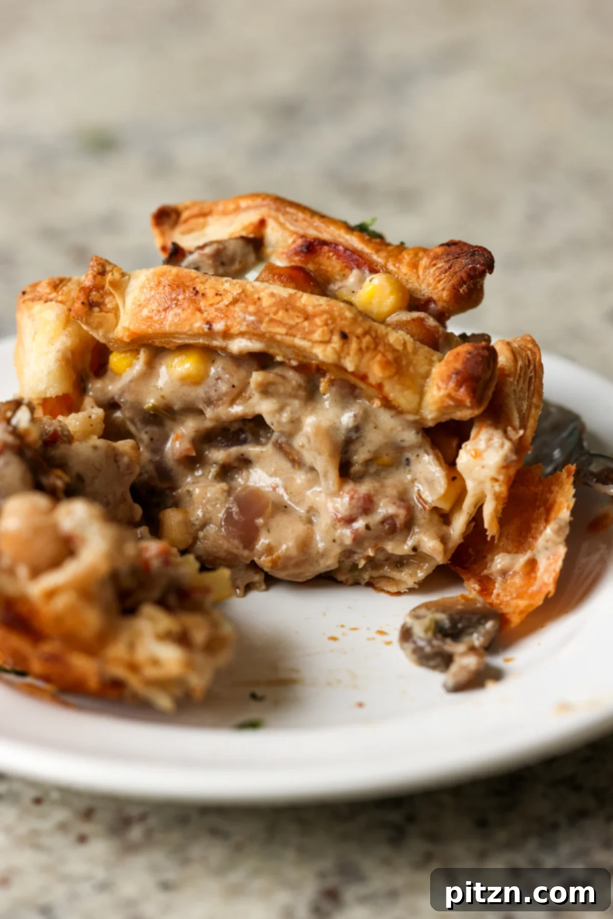 Mini pot pie cut in half, revealing the creamy, vegetable-filled Tuscan filling.
