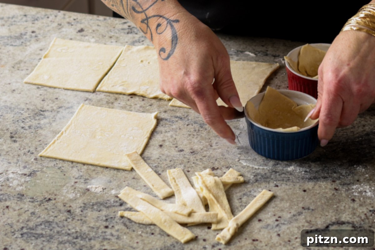 Placing puff pastry squares into greased ramekins.