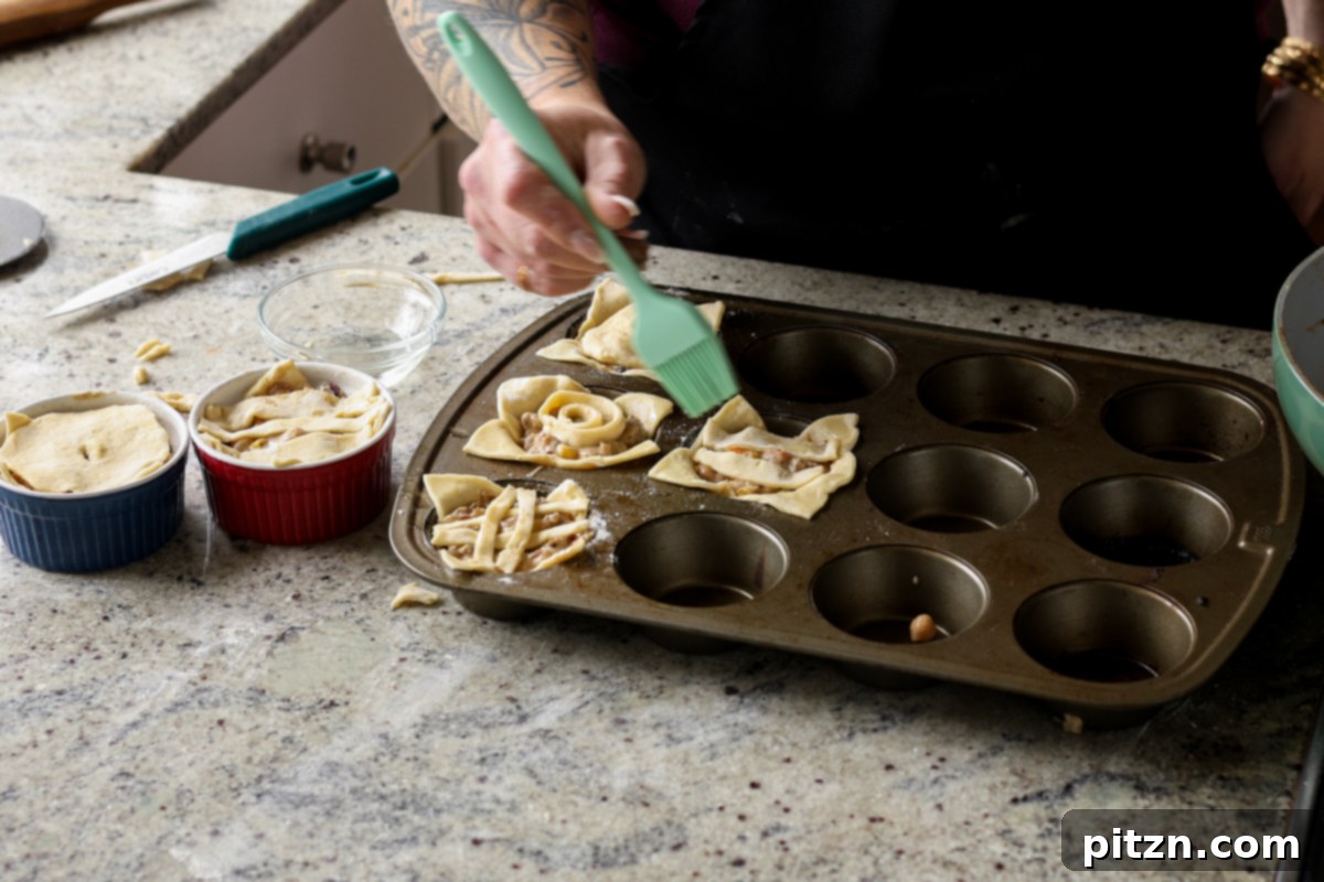 Adding lattice crust to mini pot pies and brushing with oil before baking.