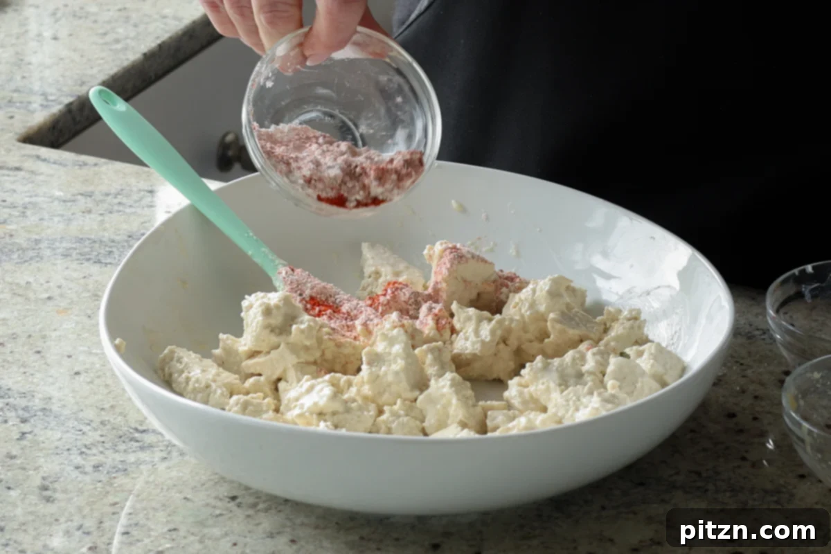 adding cornstarch and spices to the tofu
