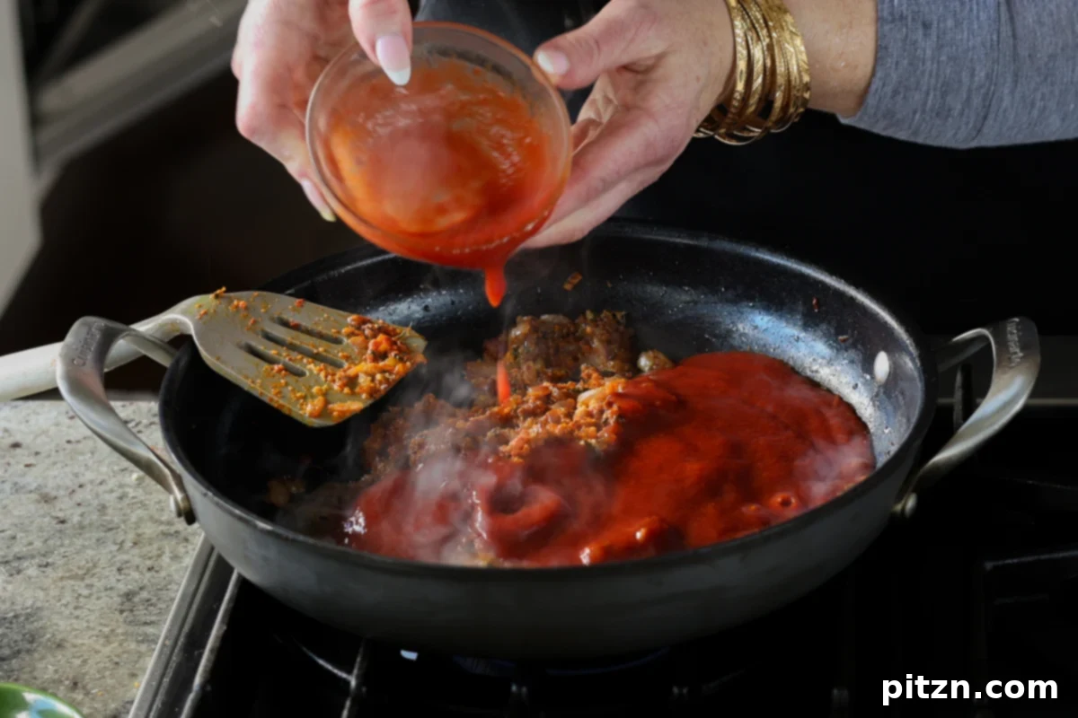 adding tomato puree to the sauce