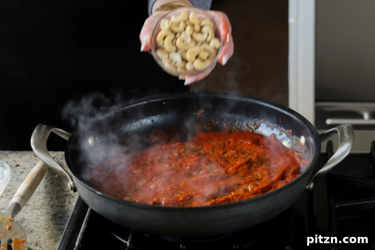 adding cashews to the sauce