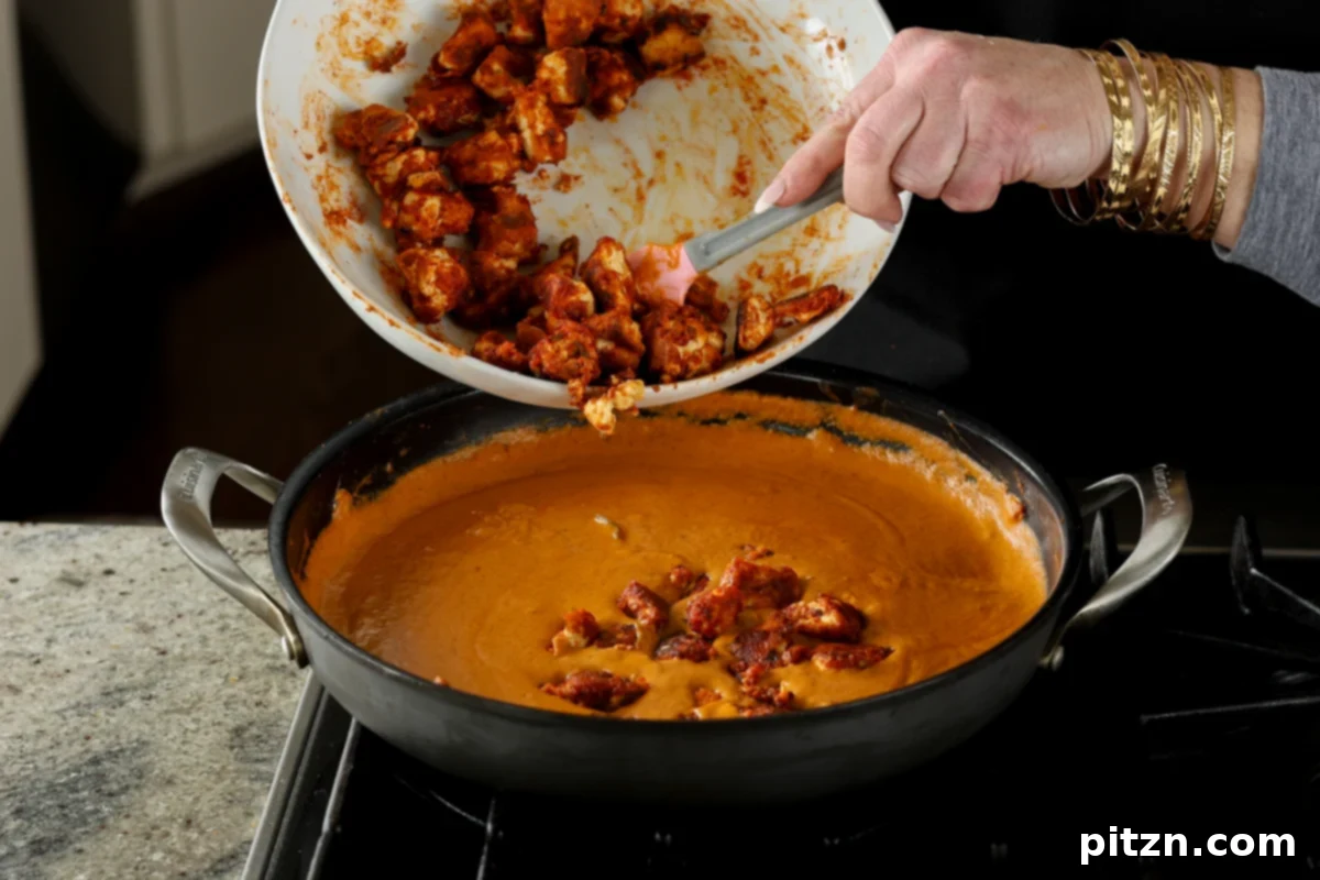 adding tofu to the butter chicken sauce