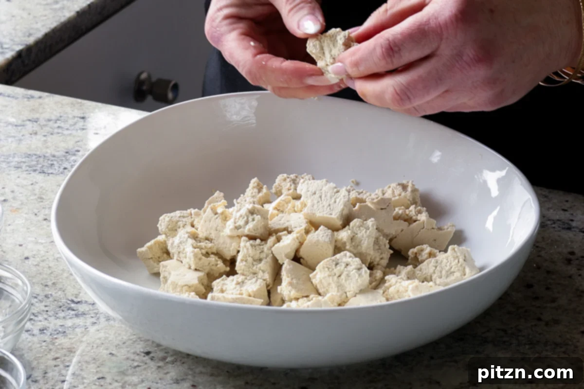 tearing the tofu into pieces