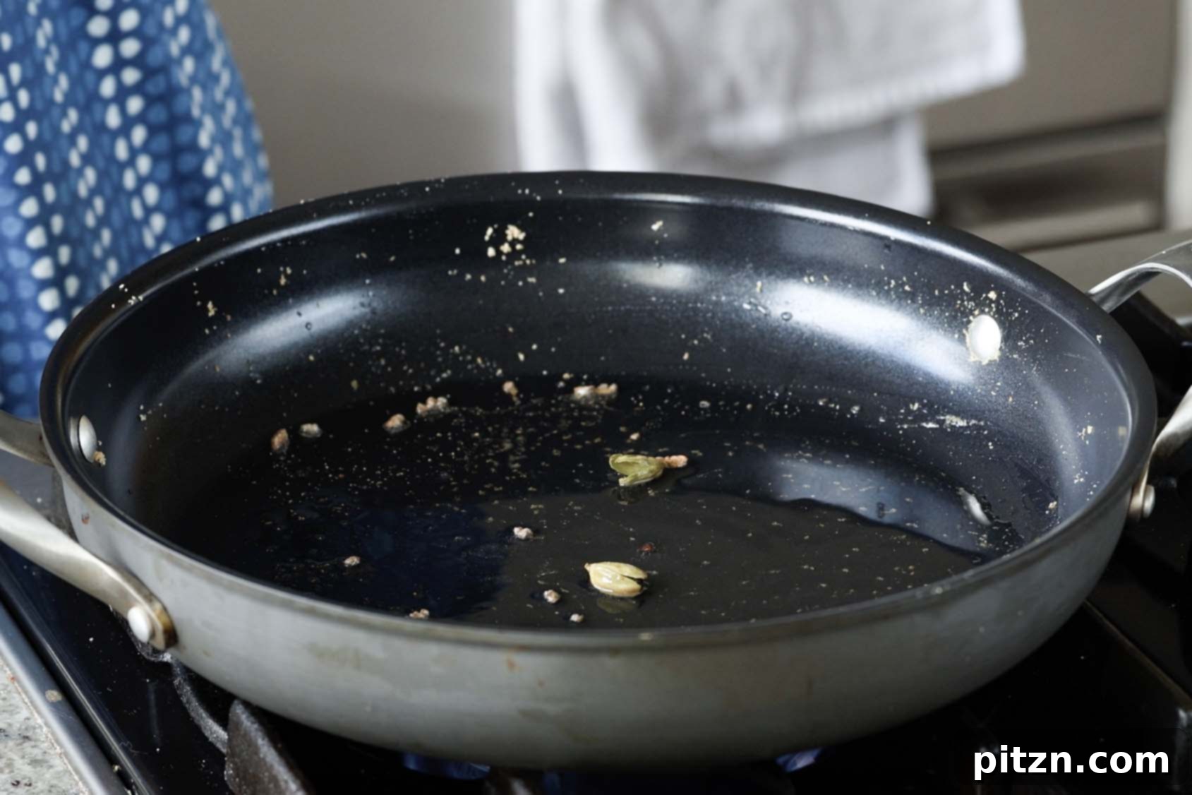 South Indian Soulmate Lentils 10 Adding green cardamom pods to hot oil in the pan.
