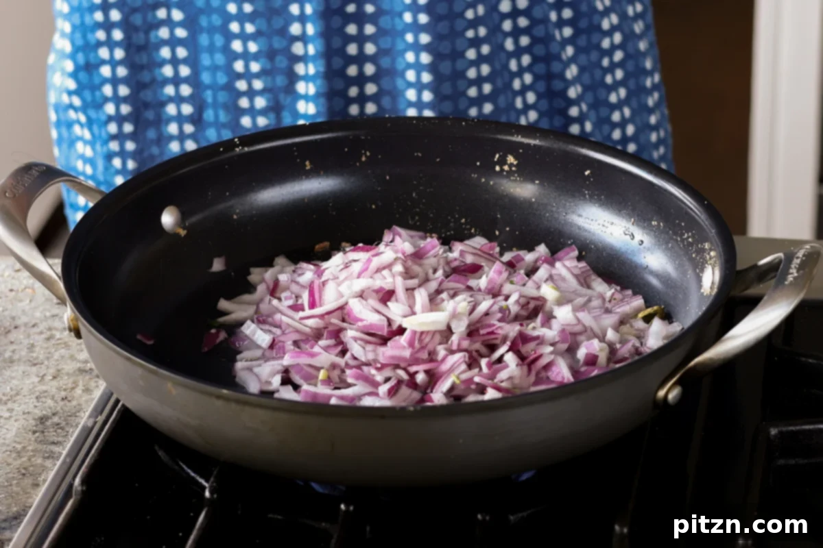 South Indian Soulmate Lentils 12 Adding chopped red onion to the pan with toasted cardamom.