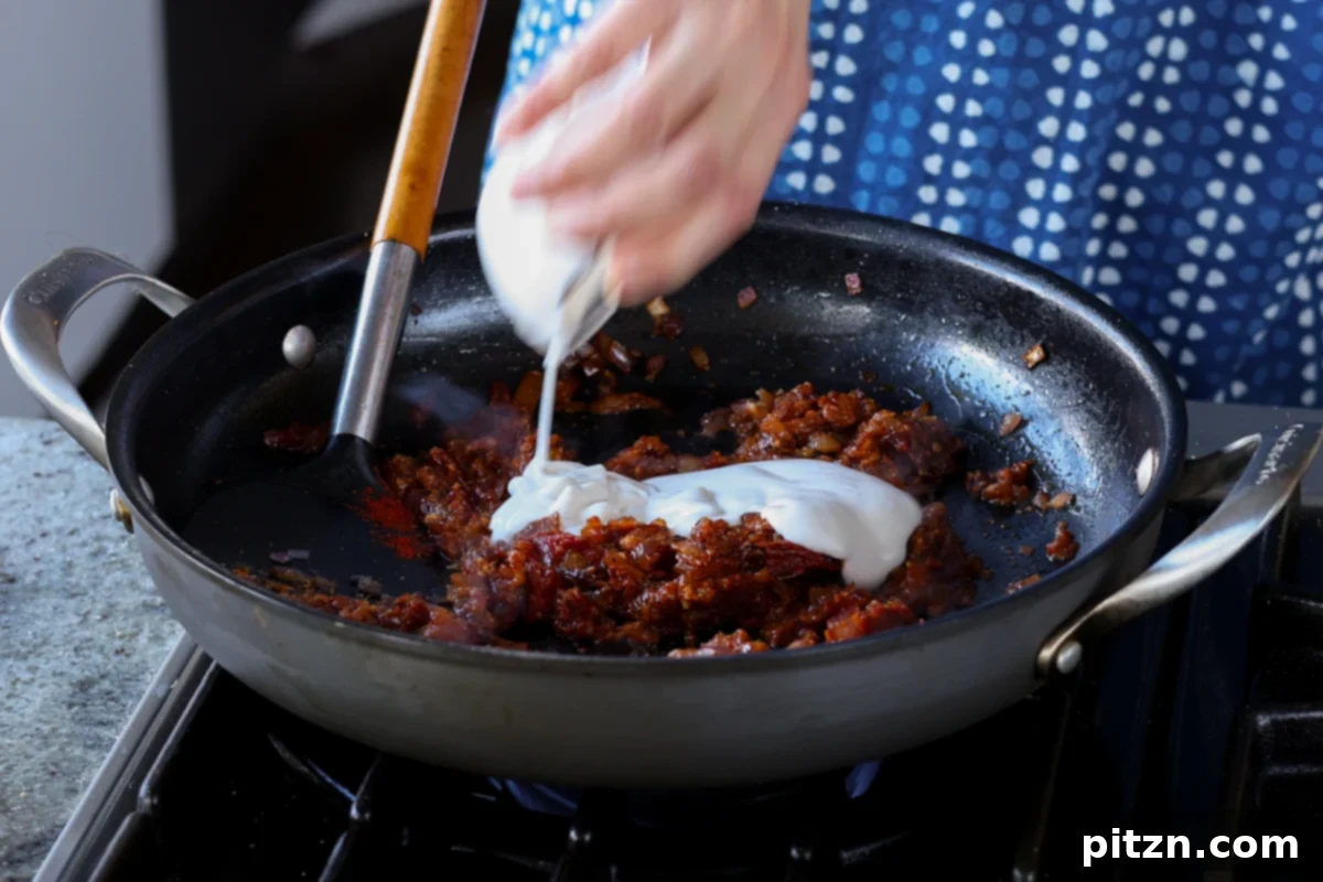 South Indian Soulmate Lentils 15 Adding non-dairy yogurt to the rich spice mixture in the pan.