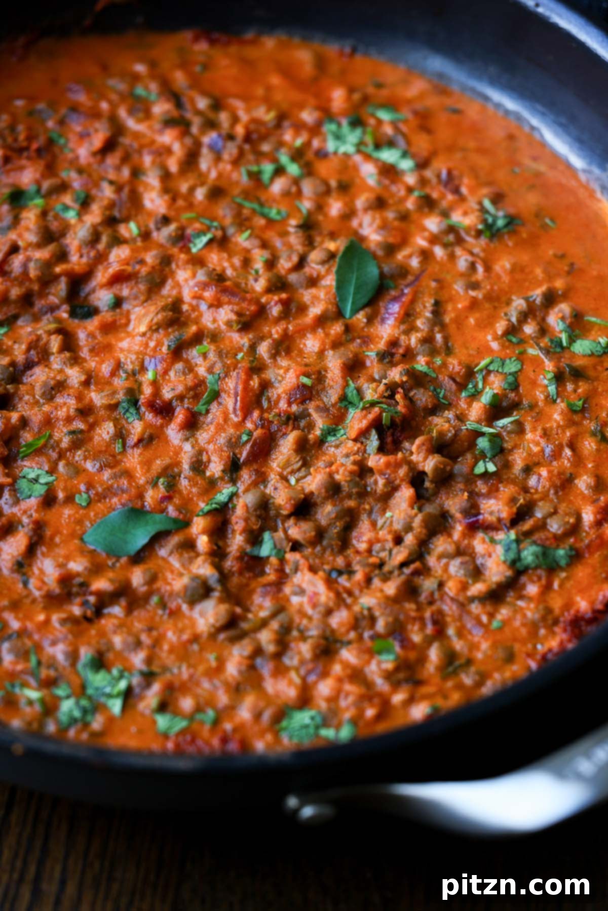 South Indian Soulmate Lentils 3 South Indian Marry Me Lentils simmering in a large pan, topped with fresh herbs.