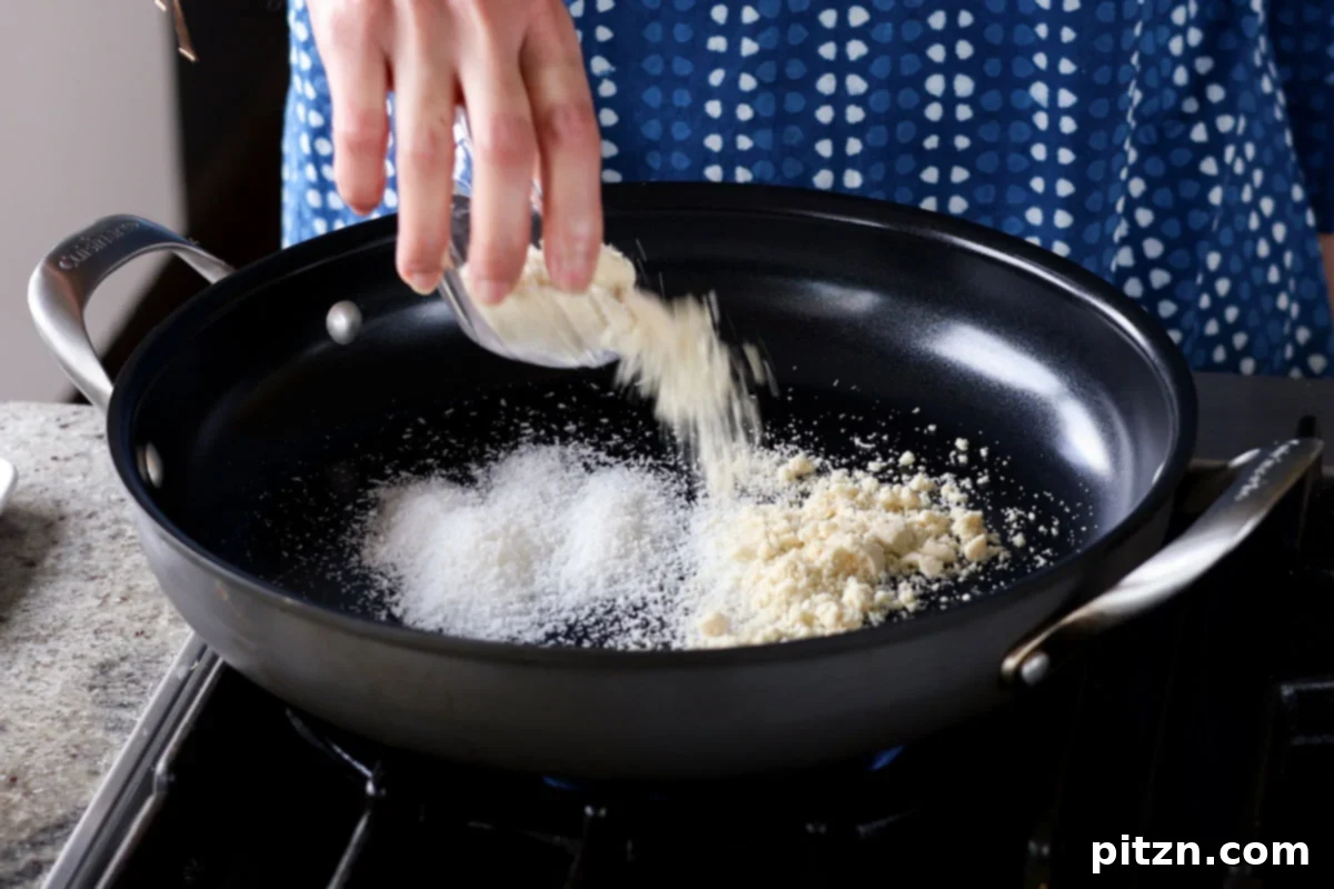 South Indian Soulmate Lentils 8 Adding shredded coconut and almond flour to a hot pan for dry toasting.