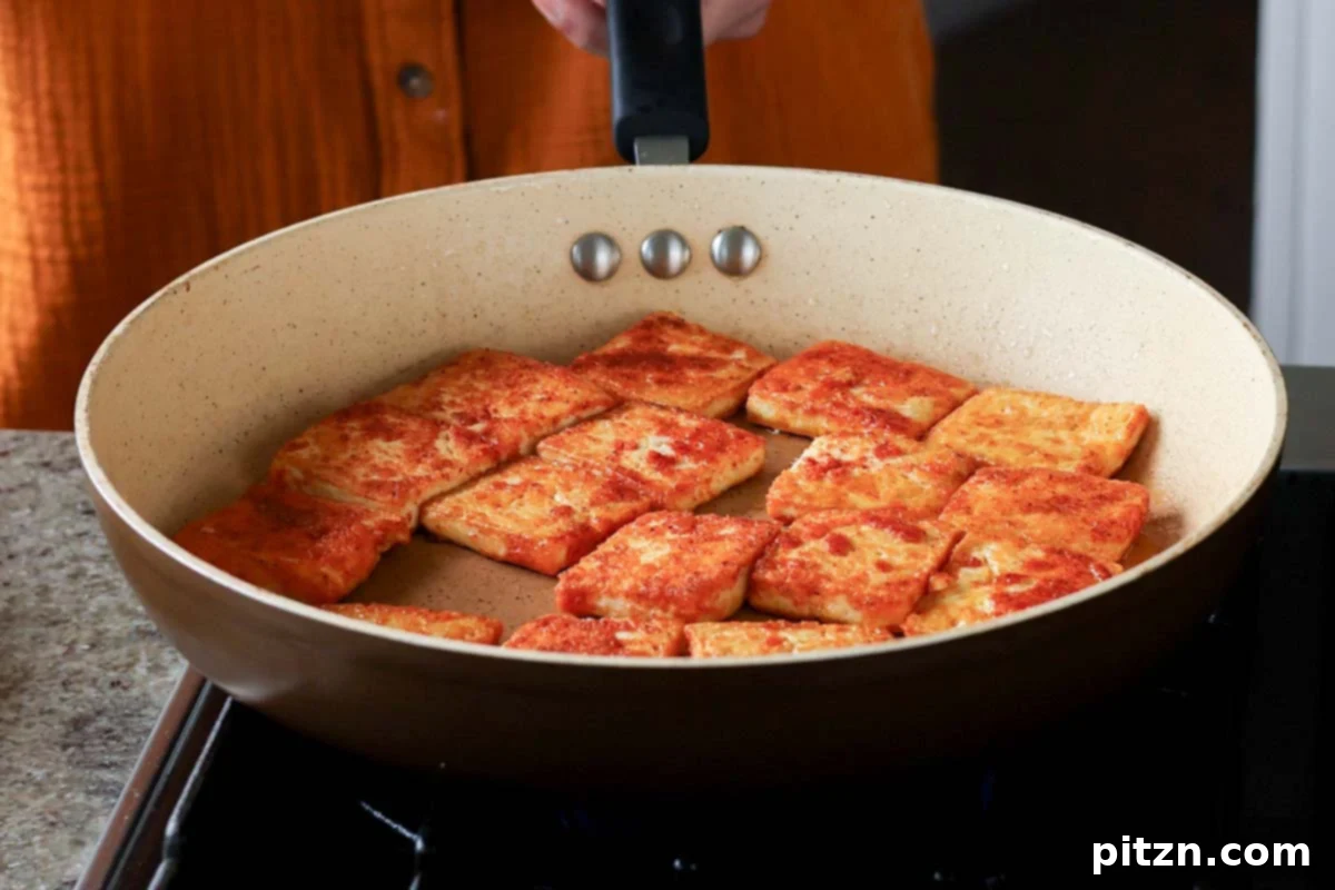Crispy, golden-brown pan-seared tofu pieces in the skillet after cooking