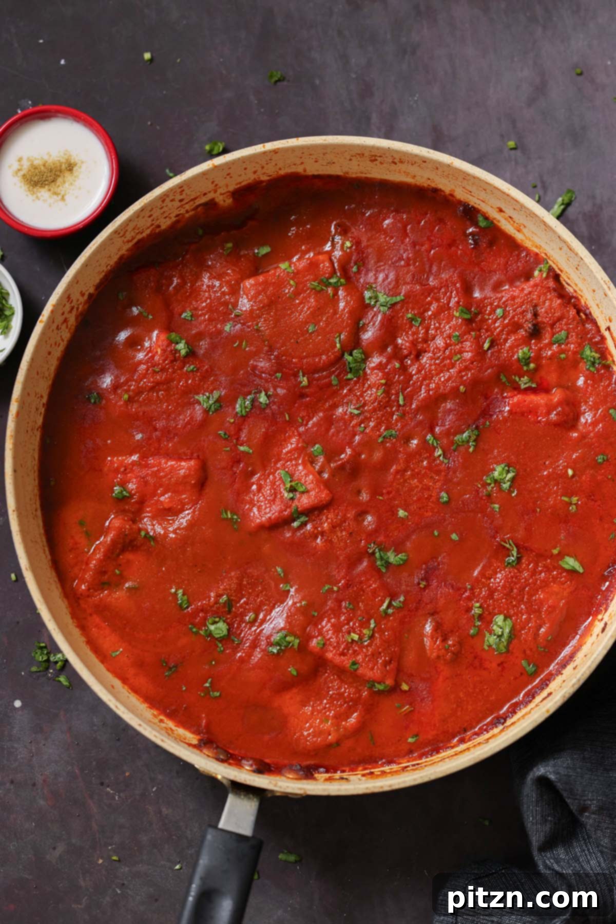 Close-up shot of a pan filled with vibrant red Vegan Kashmiri Lal Tofu
