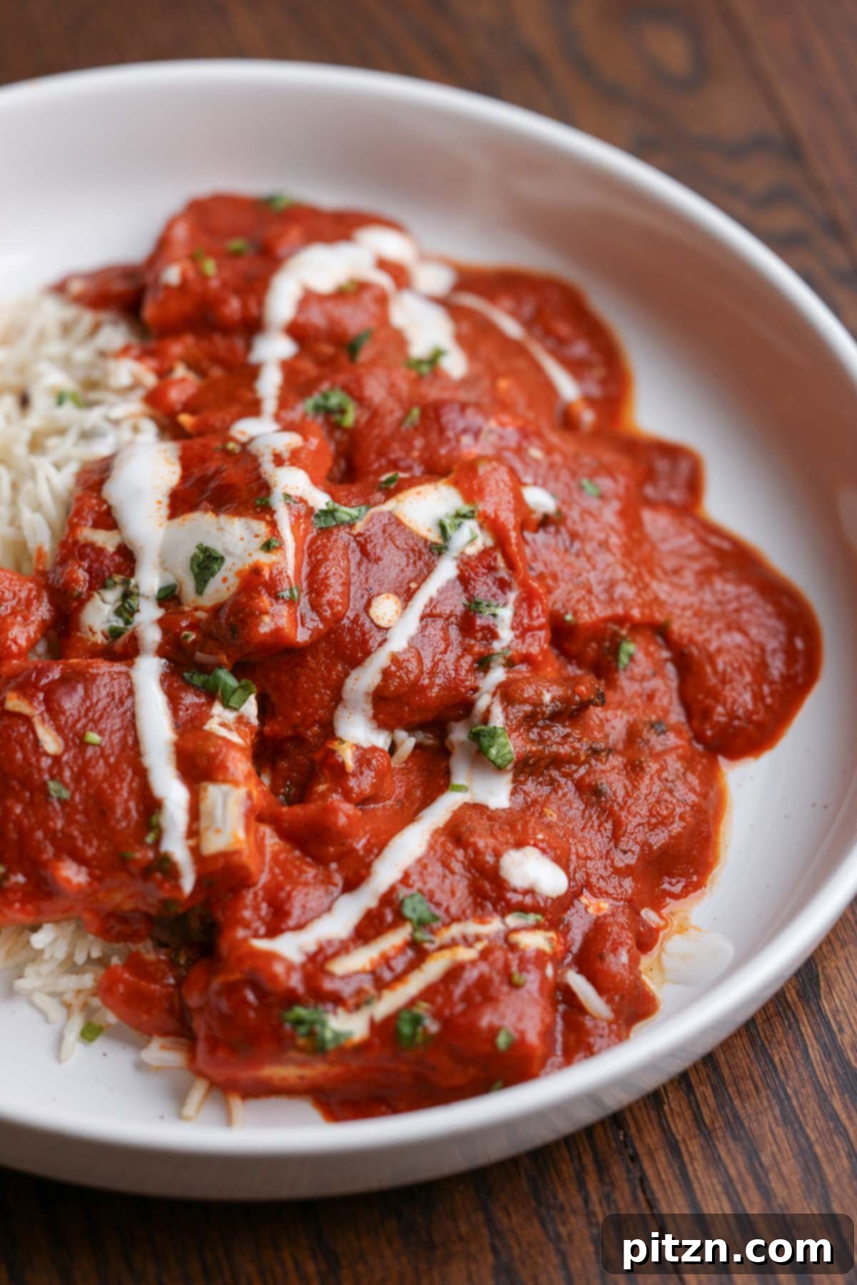A serving of Kashmiri Lal Tofu and basmati rice, garnished with non-dairy yogurt