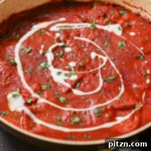 Pan of vegan Kashmiri Lal Tofu topped with non-dairy yogurt, the hero image for the recipe