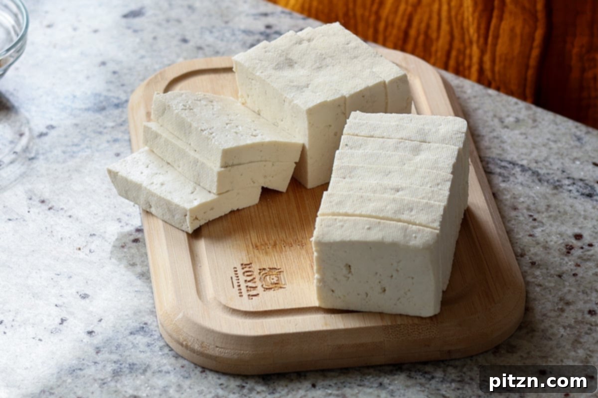 Neatly sliced block of pressed firm tofu, ready for seasoning