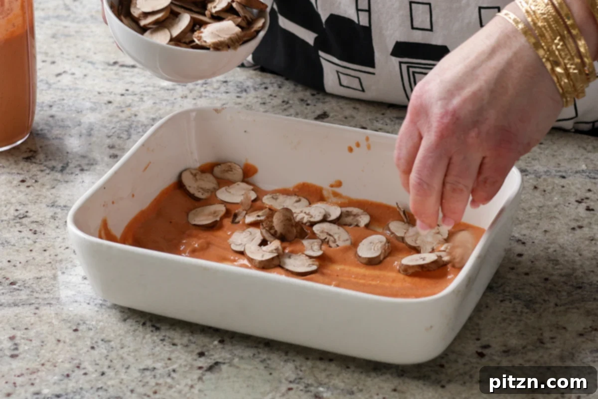 Marry Me Tofu Lasagna Bake 16 adding mushrooms to the baking dish