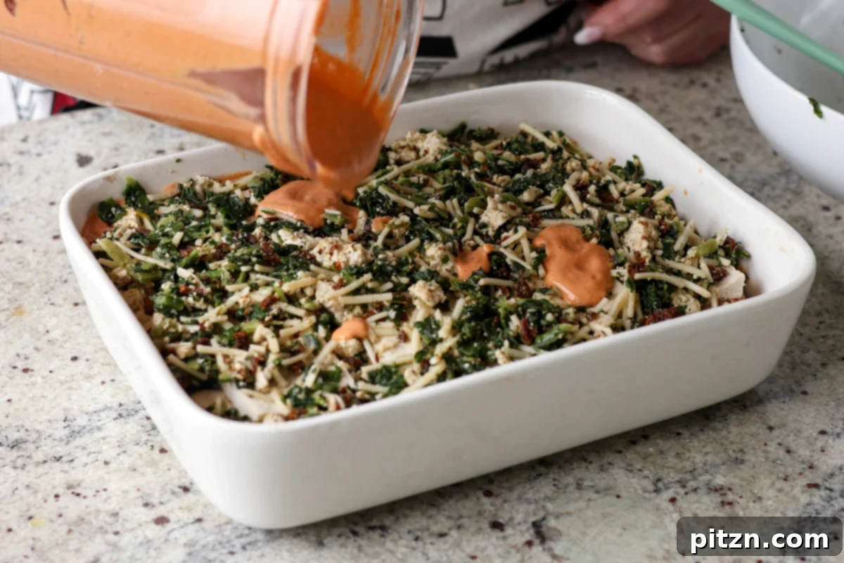 Marry Me Tofu Lasagna Bake 22 adding dollops of leftover sauce on top of the spinach filling