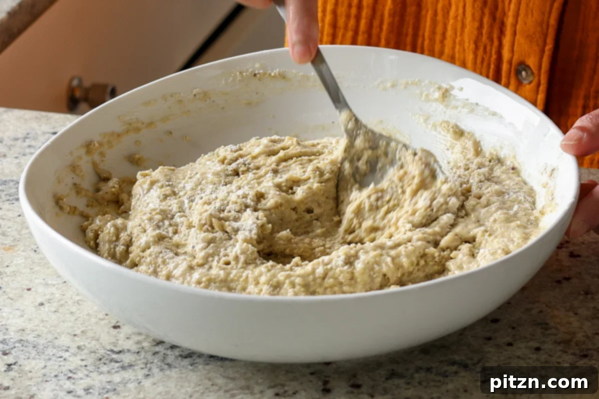 Pistachio Perfection Trio 16 Pistachio cake batter being gently mixed in a large bowl, achieving a smooth and consistent texture.