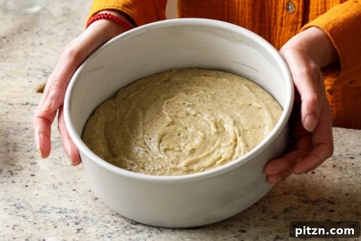 Pistachio Perfection Trio 18 Pistachio cake batter evenly distributed in the pan, waiting to be baked, showcasing its ready-to-bake state.