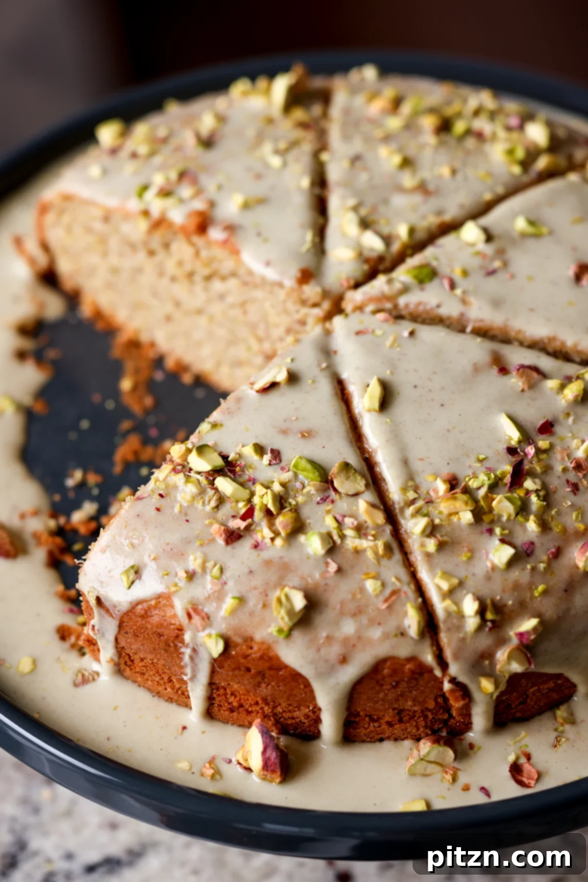 Pistachio Perfection Trio 4 A whole triple pistachio cake with a slice removed, showcasing the layered texture of the cake and the thick, creamy frosting.