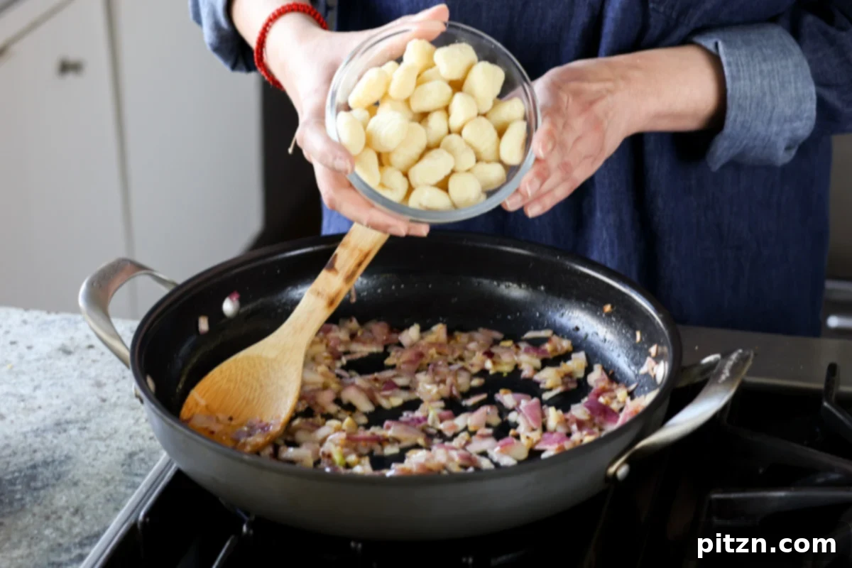 Adding uncooked gnocchi directly to the pan with sautéed aromatics.