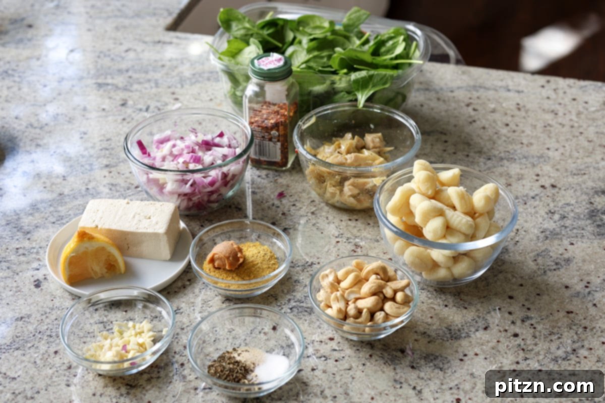 Ingredients for spinach artichoke gnocchi laid out on a kitchen counter, showcasing fresh produce.