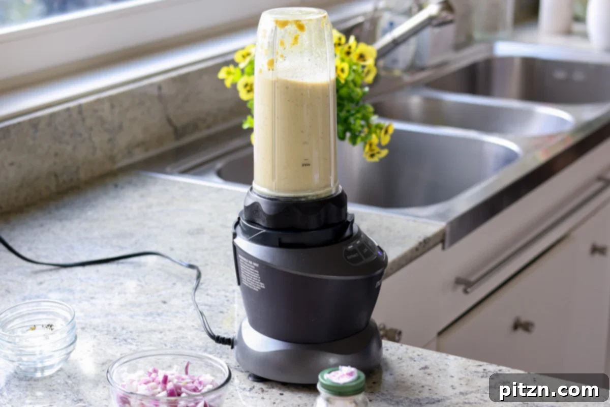 Blended creamy spinach artichoke sauce in a blender.